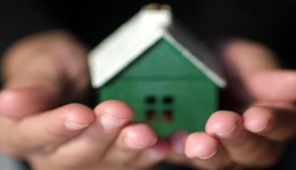 photo of hands holding a house