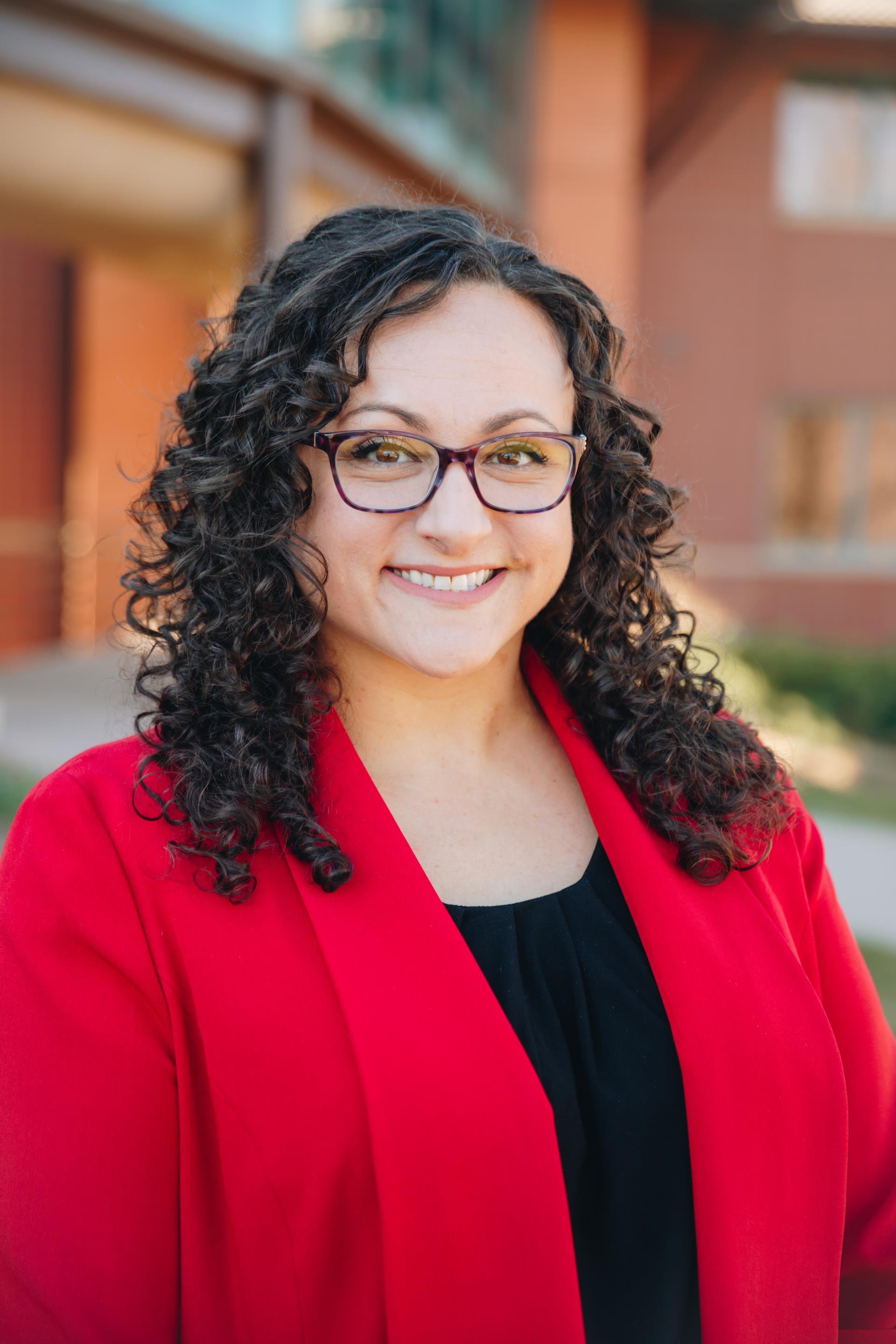 headshot of Nicole Yost, director of communications and engagement for the City of Loveland standing in front of City Hall.