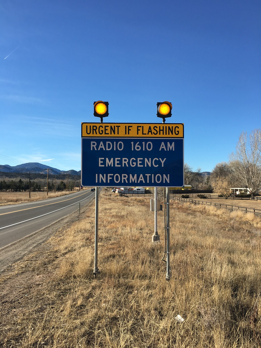 A sign saying when flashing, tune into 1610 AM for emergency information is shown.