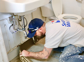 A contractor finalizes the trim in the resource center bathroom