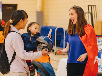 A mom and child visit with a Children's Day event sponsor.